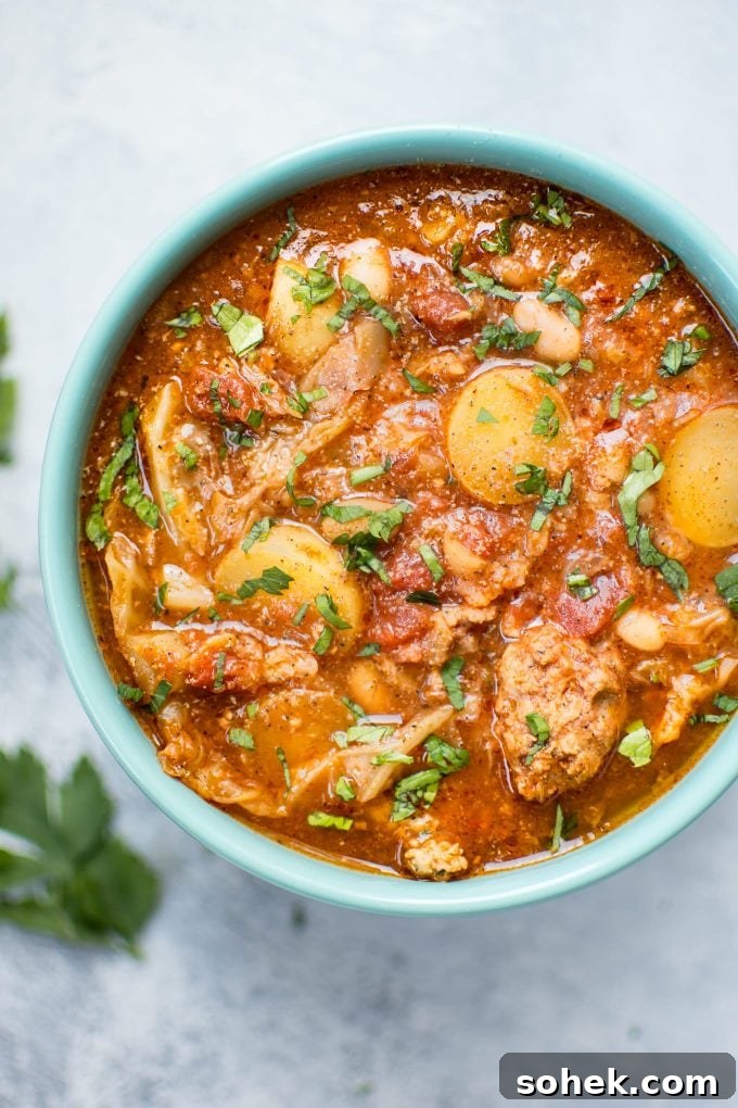 Hearty Crockpot Cabbage Soup with Sausage, Beans & Potatoes 2 Crockpot cabbage soup with potatoes, beans, and sausage in a teal bowl