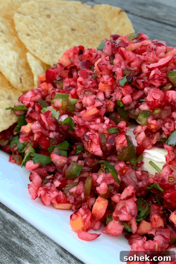 Zesty Cranberry Jalapeño Salsa Recipe for Holiday Parties 4 Cranberry salsa over a block of cream cheese on white platter with chips