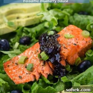 Salmon Salad with Balsamic Blueberry Dressing 2 Green lettuce is adorned with a thick piece of salmon topped with a balsamic blueberry sauce. Sliced avocado sits in the background and the recipe title "Salmon Salad with Balsamic Blueberry Sauce" is printed across the top.