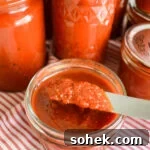 Canned Pizza Sauce from Fresh or Frozen Tomatoes — Simple Recipe 8 thick pizza sauce on knife over jar