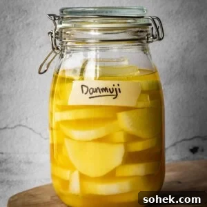 A jar with sliced daikon radish in a pickling solution, with a Danmuji label.