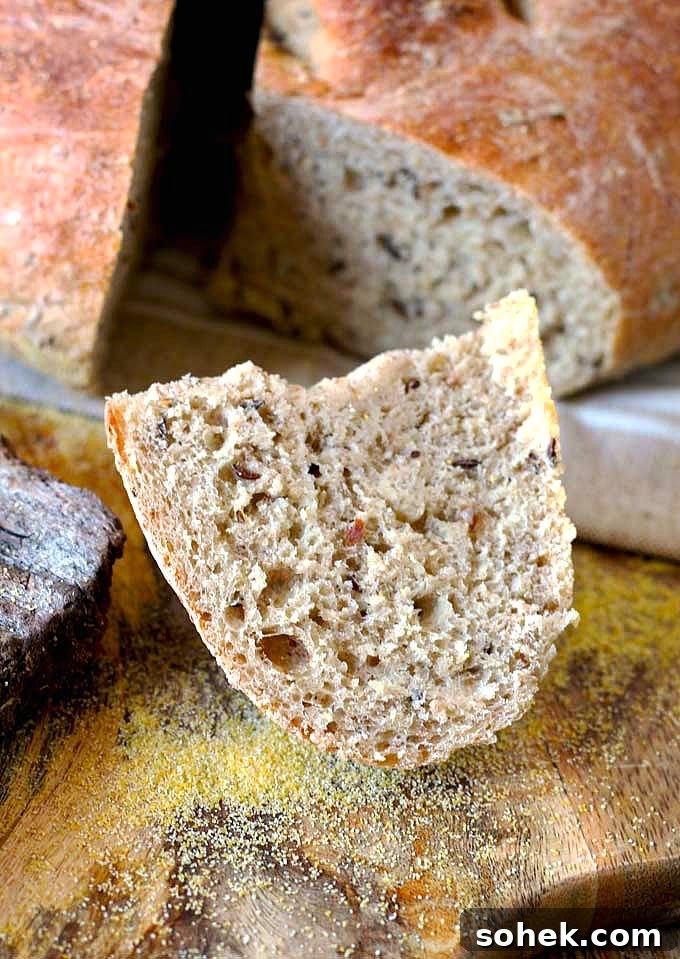 Farmer-Style German Bauernbrot: Rustic Traditional Rye Bread Recipe 3 A piece of German Farmer's bread on a wooden cutting board.