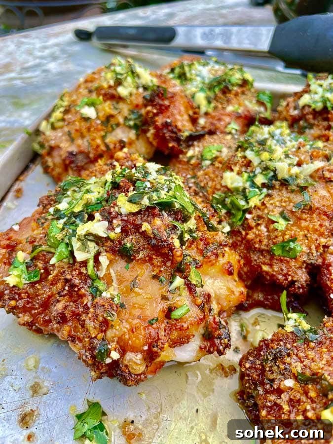 Juicy Grilled Italian Chicken Thighs with Herb Marinade 2 Grilled Italian Chicken Thighs on metal baking sheet