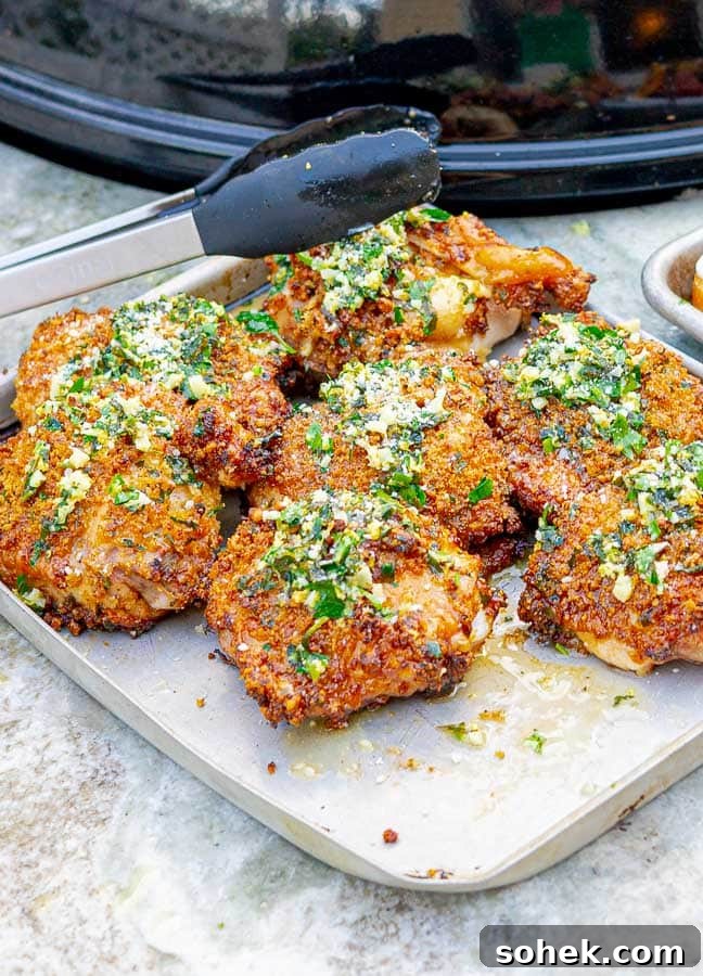 Juicy Grilled Italian Chicken Thighs with Herb Marinade 8 Grilled Italian Chicken Thighs on metal baking sheet with tongs