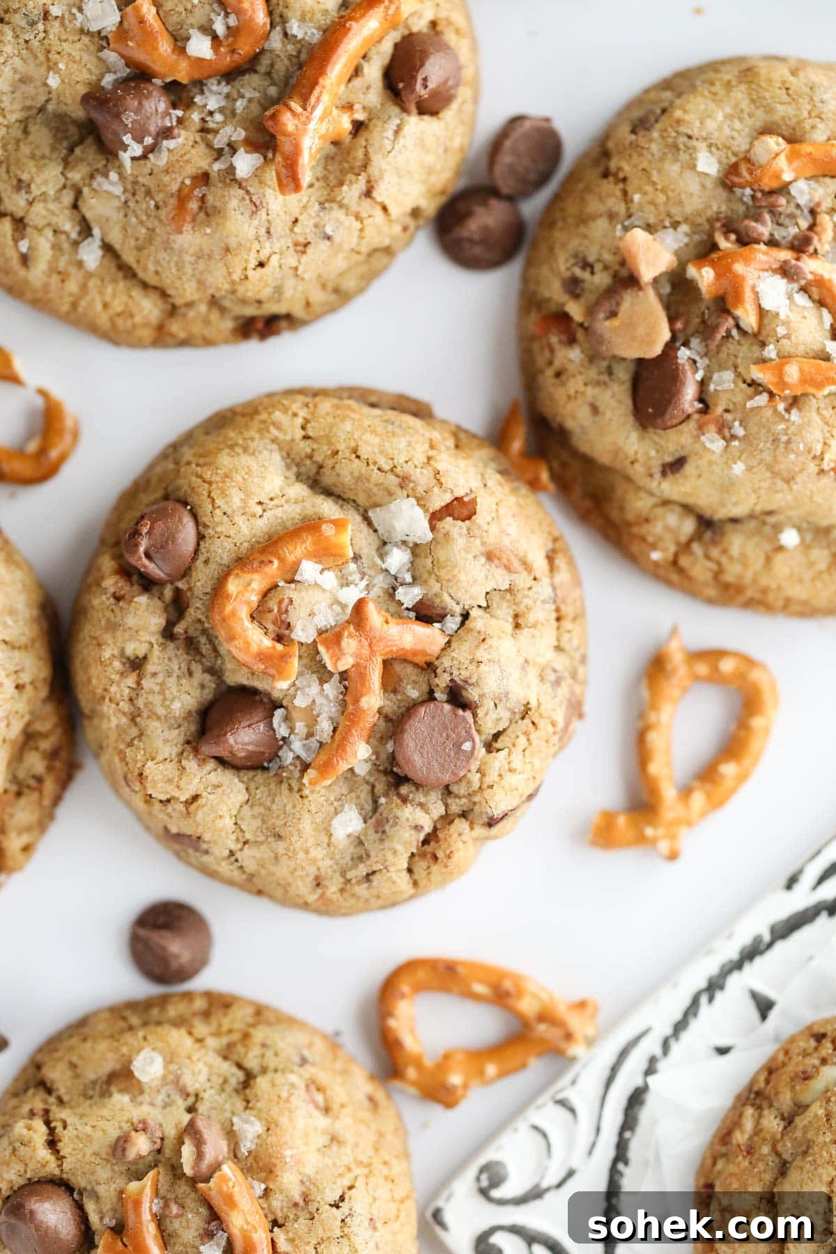 Ultimate Kitchen Sink Cookies Recipe: Loaded Chocolate Chip Bars 6 kitchen sink cookies spread out on a white surface.