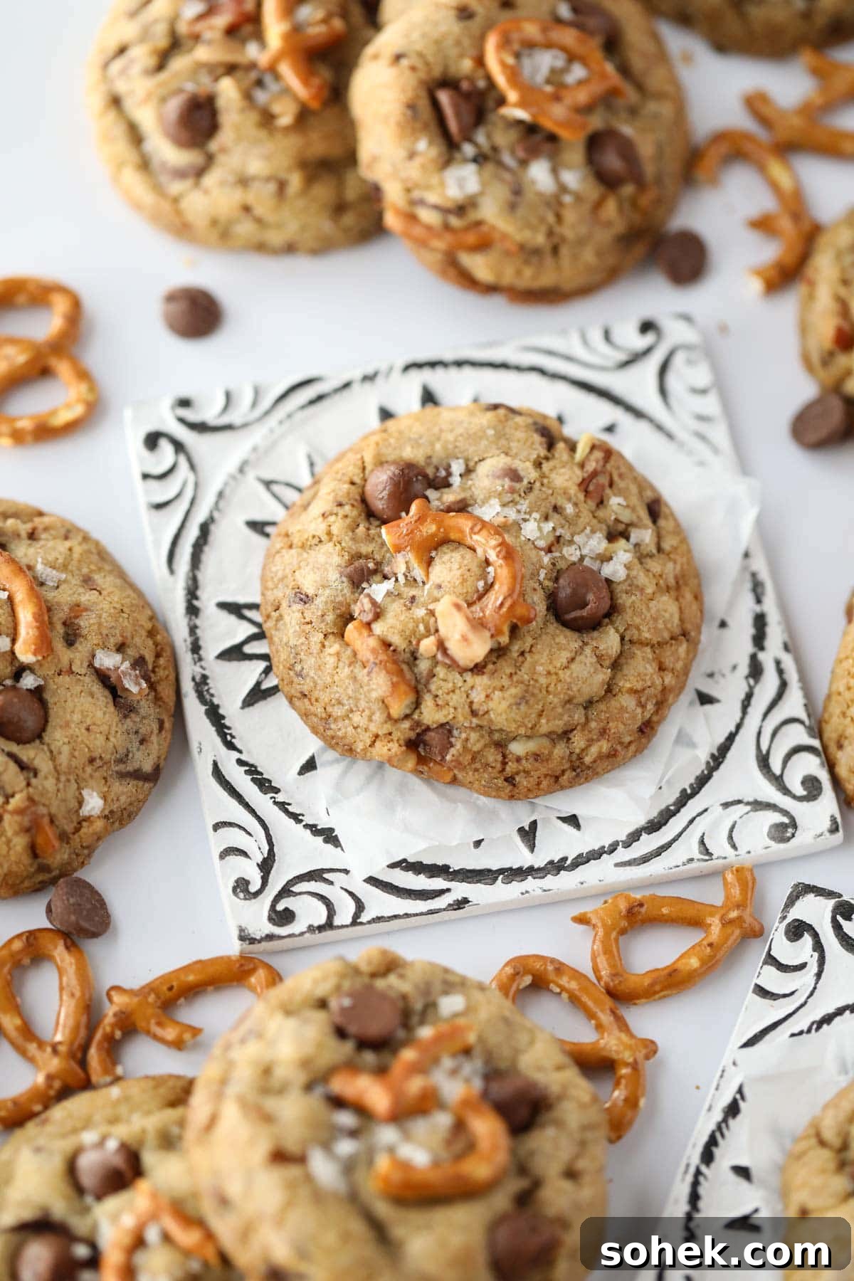 Ultimate Kitchen Sink Cookies Recipe: Loaded Chocolate Chip Bars 8 kitchen sink cookies spread out on a white surface.