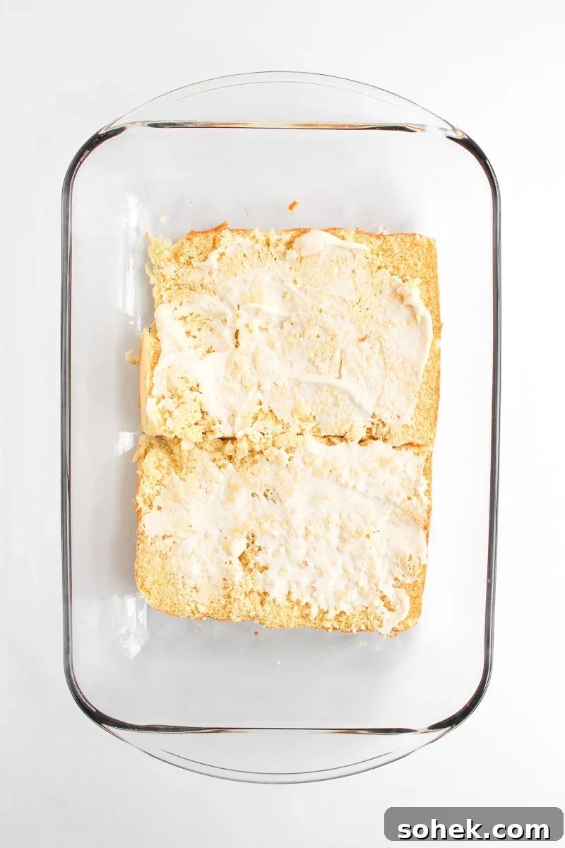 Mayonnaise is spread on bottom half of the Hawaiian rolls.