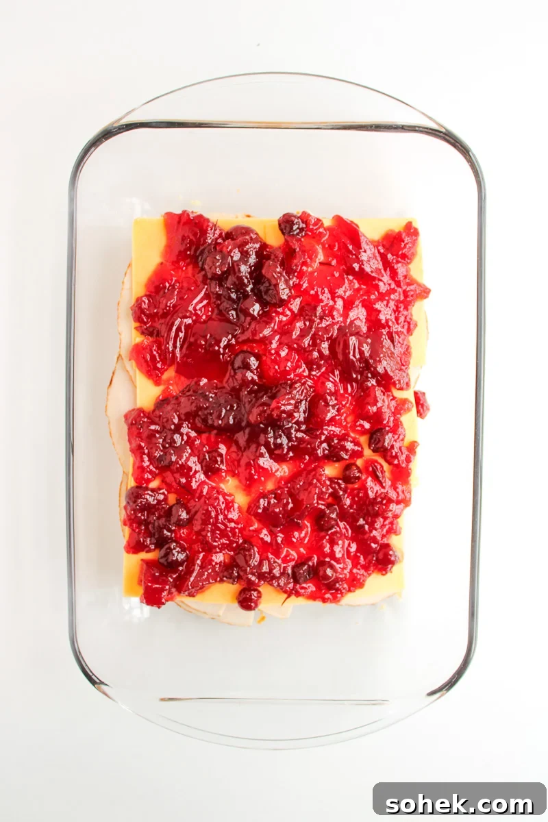 Cranberry sauce is spread on top of the cheese layer.