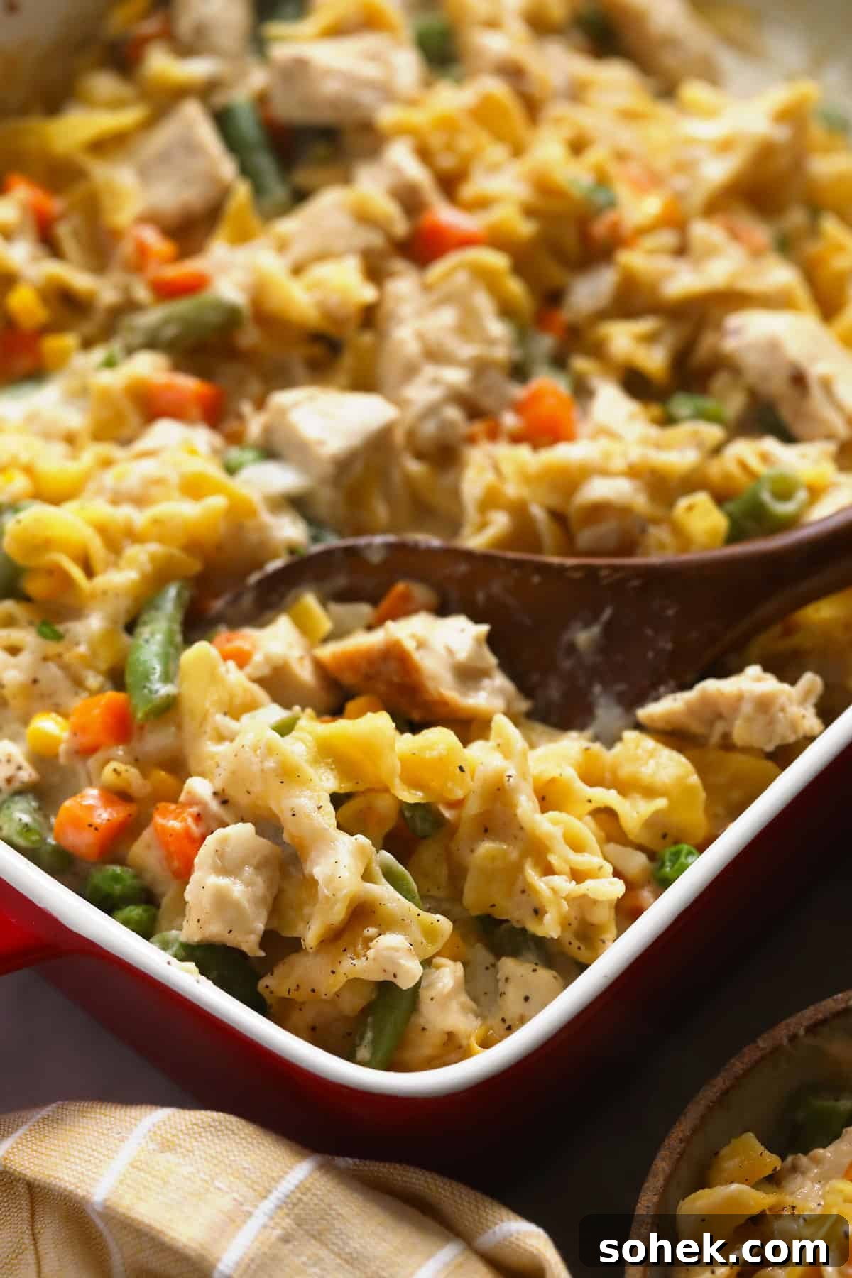 This Creamy Chicken Noodle Casserole is comfort food at its finest! Everything you love about chicken noodle soup, but as a flavor-packed casserole. Enjoy! Creamy chicken noodle casserole in a casserole dish.