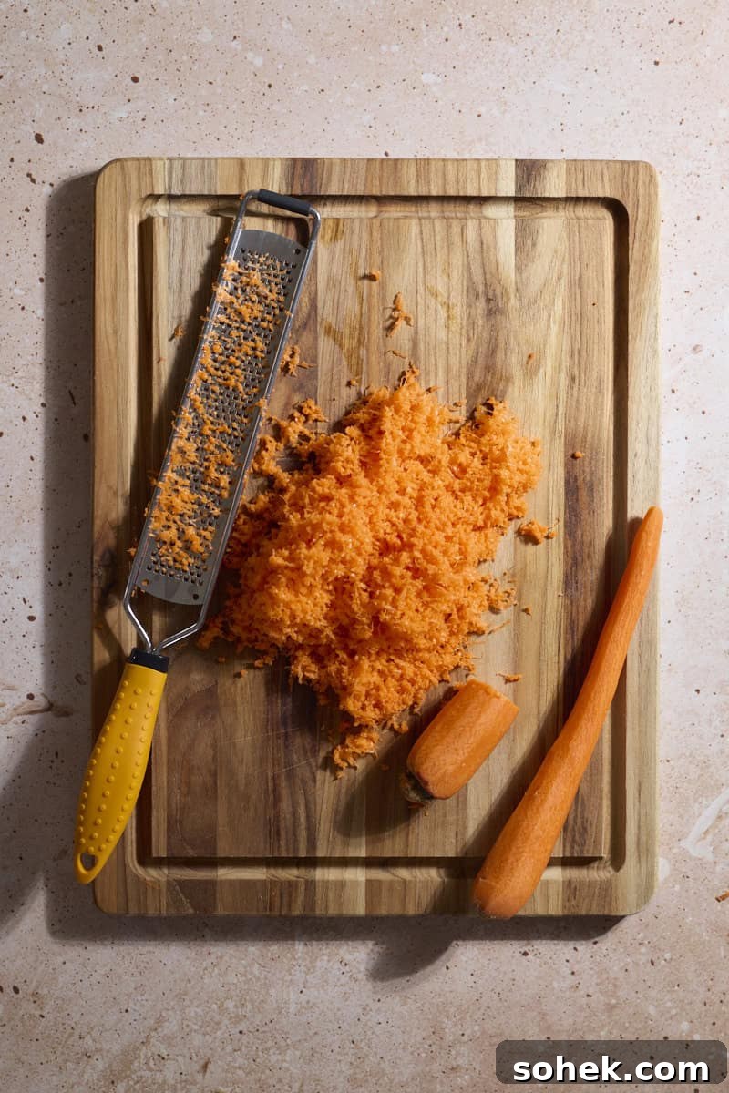 Sourdough Discard Carrot Cake Recipe for Moist, Flavorful Loaf 5 Carrots grated on a wooden cutting board.