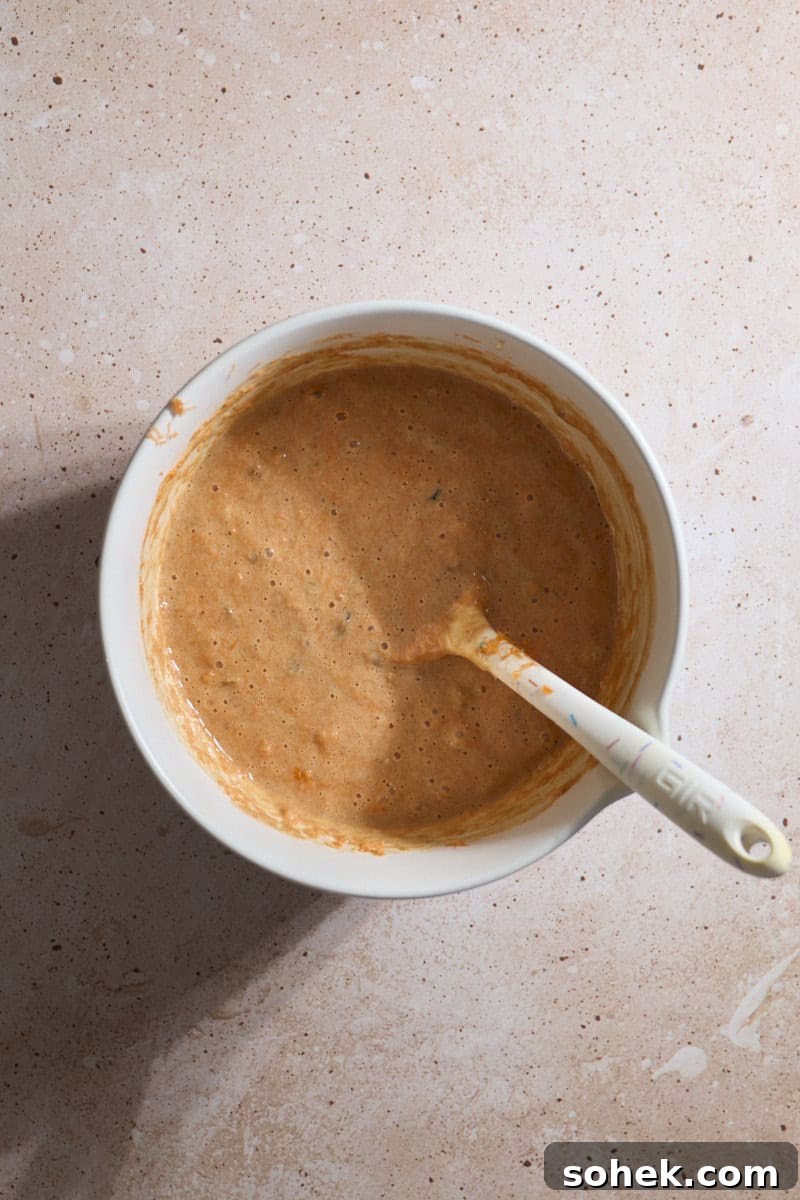 Sourdough Discard Carrot Cake Recipe for Moist, Flavorful Loaf 8 Cake batter mixed in a white bowl.
