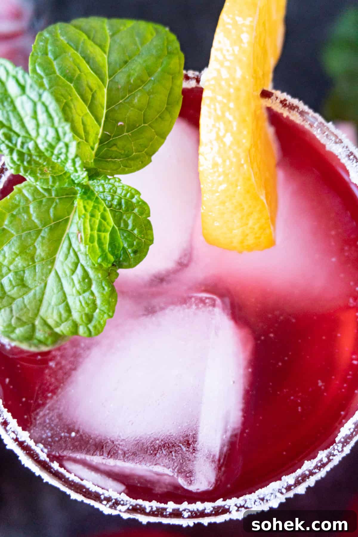 Cranberry Mint Julep Cocktail Recipe for Holiday Gatherings 3 Cranberry julep top of drink showing mint leaves and orange slice as garnish.