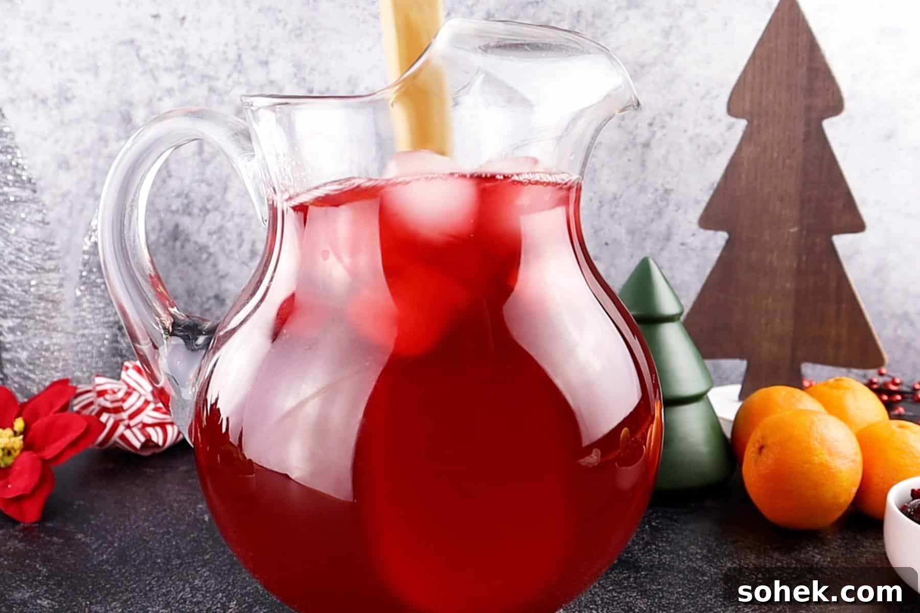 Cranberry Mint Julep Cocktail Recipe for Holiday Gatherings 6 stirring cranberry mint julep in pitcher.
