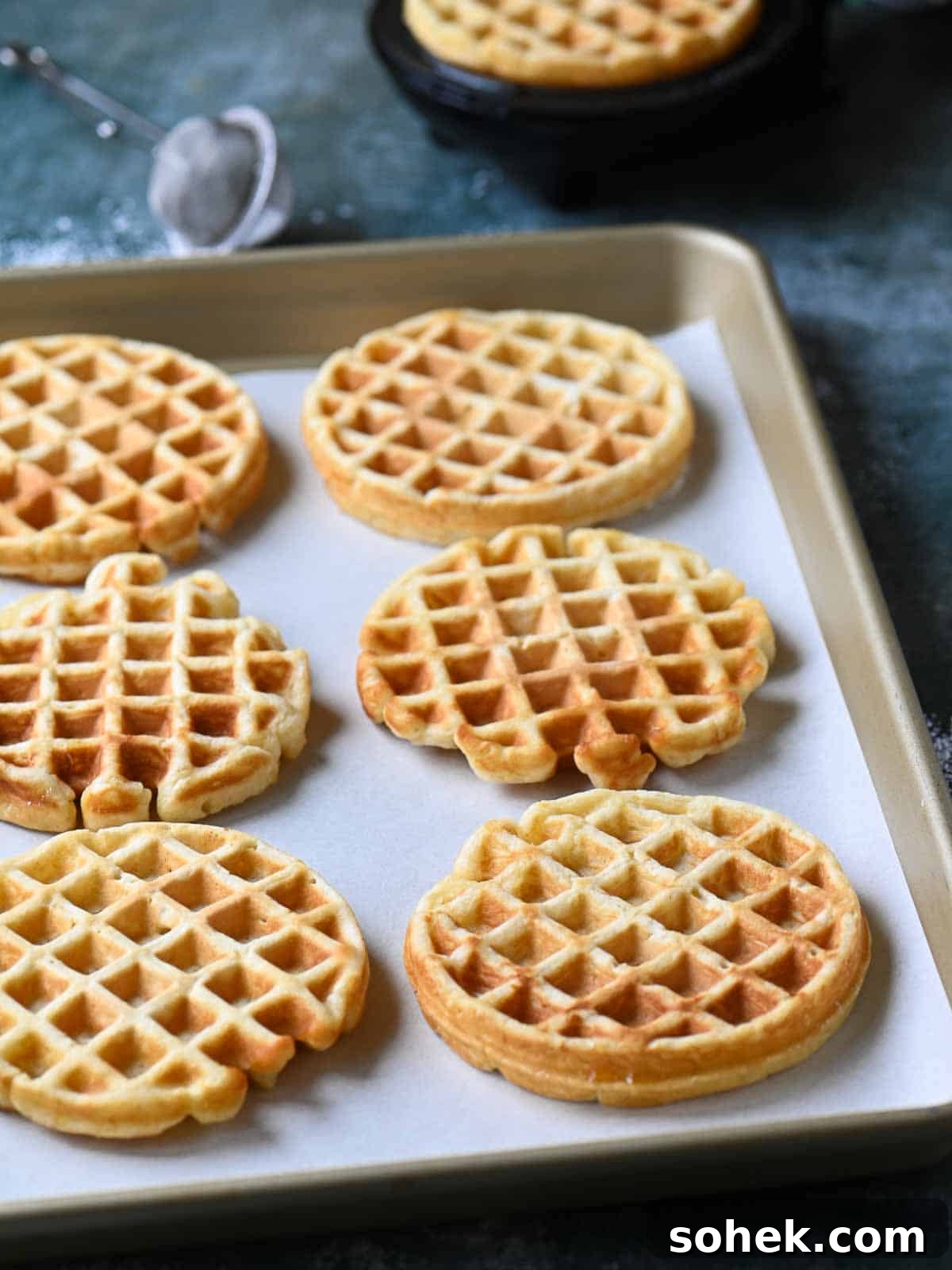 Mini Toaster Waffles: Quick Crispy Breakfast Bites 3 Six cooked waffles on a baking tray.