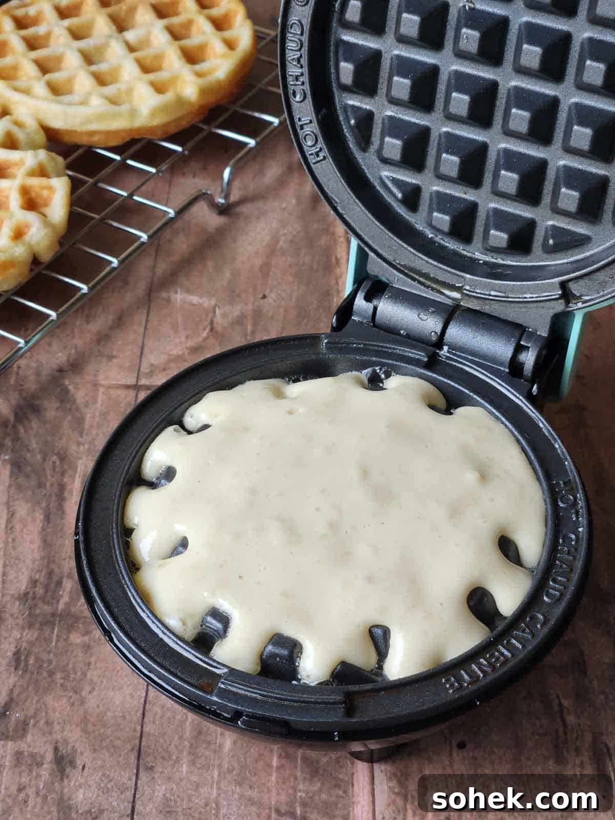 Mini Toaster Waffles: Quick Crispy Breakfast Bites 6 Waffle batter on cooking on a mini waffle maker.