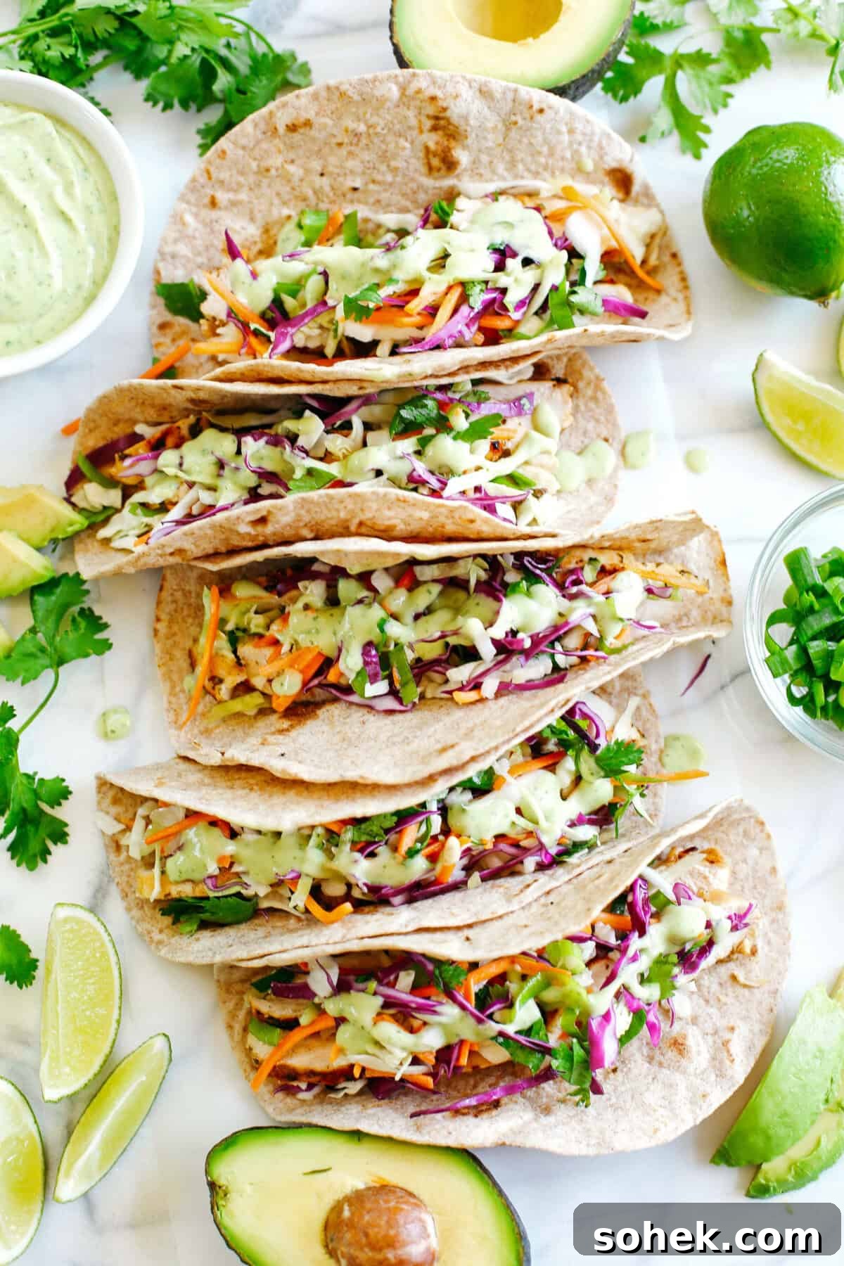 Cilantro Lime Chicken Tacos topped with tangy coleslaw and avocado crema