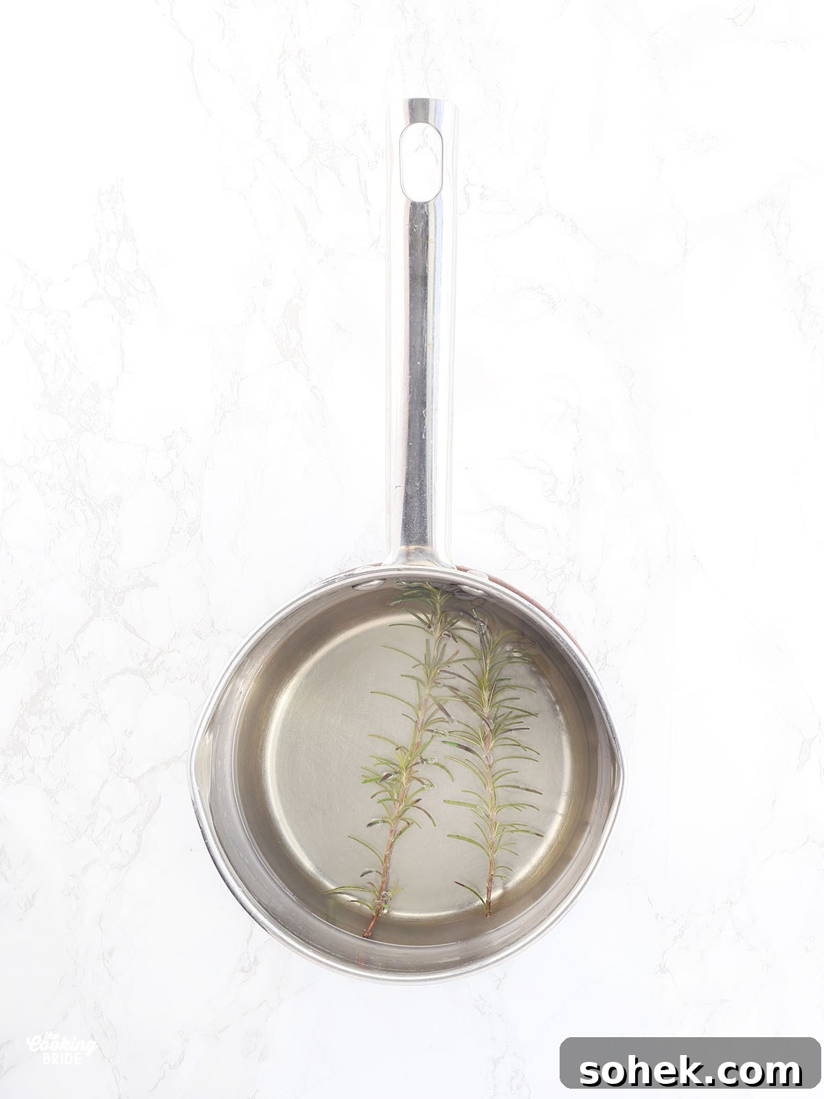 Rosemary Gin Grapefruit Cocktail Recipe with Citrus Twist 4 two sprigs of rosemary floating in a pan of simple syrup