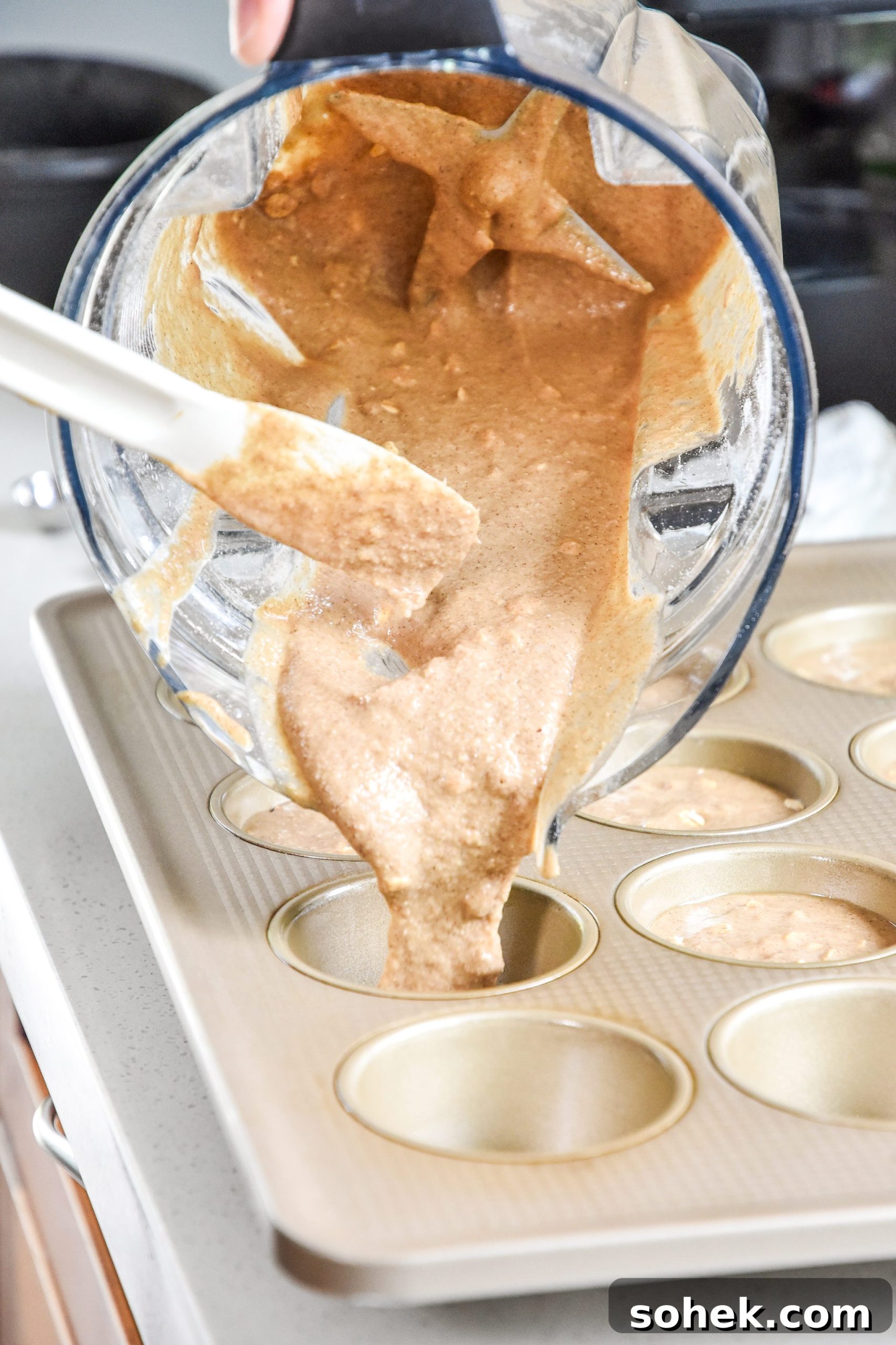 pouring batter from the blender into the muffin pan