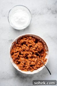 Chocolate Peanut Butter Muddy Buddies Recipe 5 Chex cereal coated in chocolate and peanut butter, with a bowl of powdered sugar nearby.