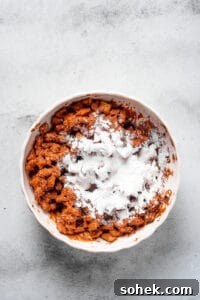 Chocolate Peanut Butter Muddy Buddies Recipe 6 Powdered sugar dumped in a bowl of coated cereal.
