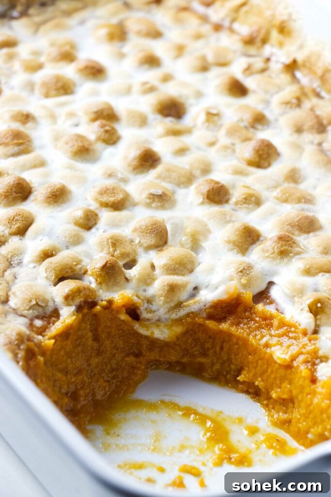 Marshmallows on mashed sweet potatoes in a hot casserole dish.