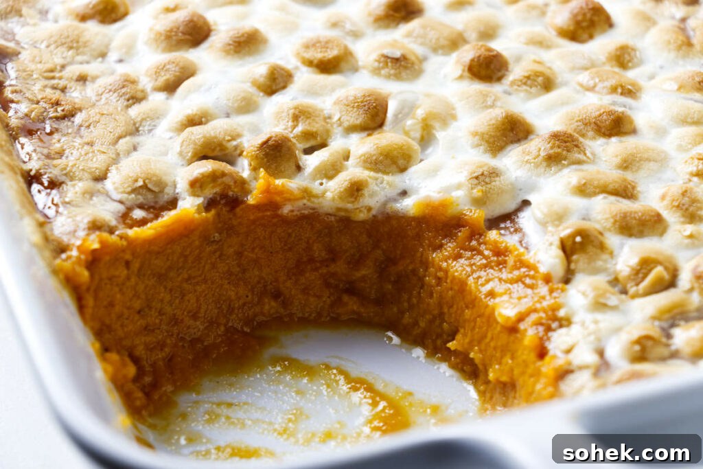 A sweet potato and marshmallow casserole in a white dish.