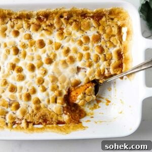 A mashed sweet potato casserole in a baking dish topped with marshmallows.