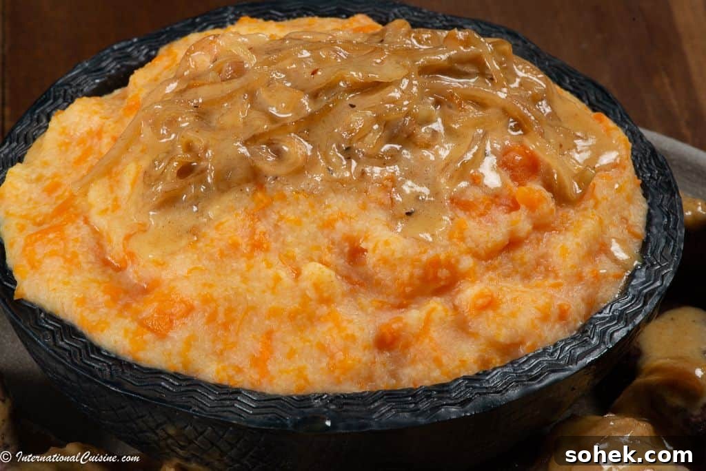 A bowl full of pumpkin pap served with a little cream sauce and onions.
