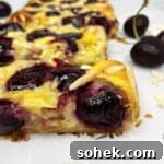 Sliced cherry tart featuring cherries on parchment paper.