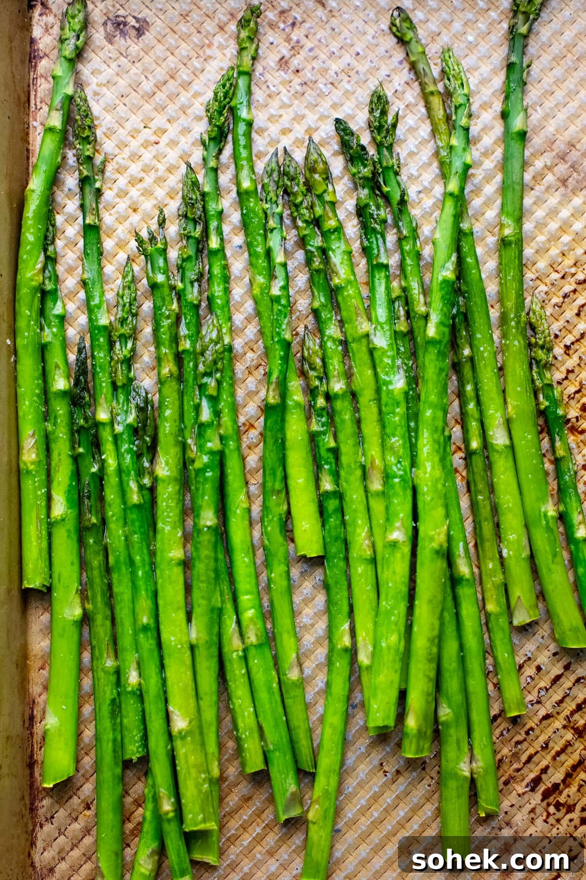 green asparagus arranged on copper sheet pan.