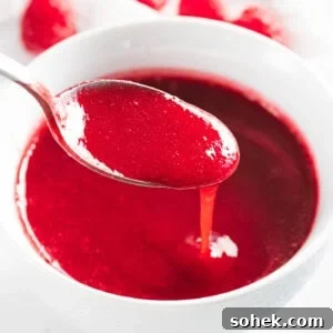 Homemade Raspberry Sauce Recipe for Desserts and Toppings 13 Raspberry sauce poured off a spoon.