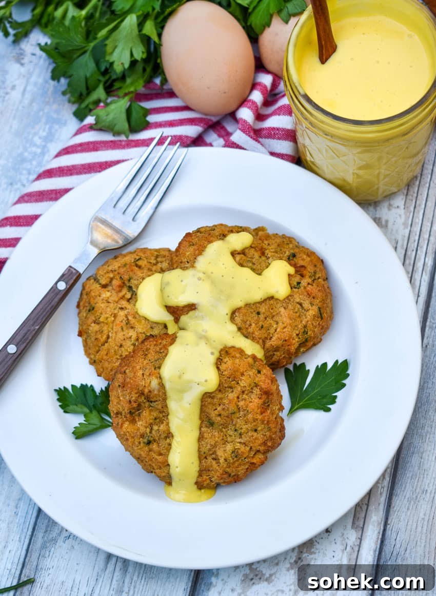 Quick Blender Hollandaise Sauce Recipe for Perfect Creamy Results 6 three crab cakes topped with homemade hollandaise sauce on a small white plate