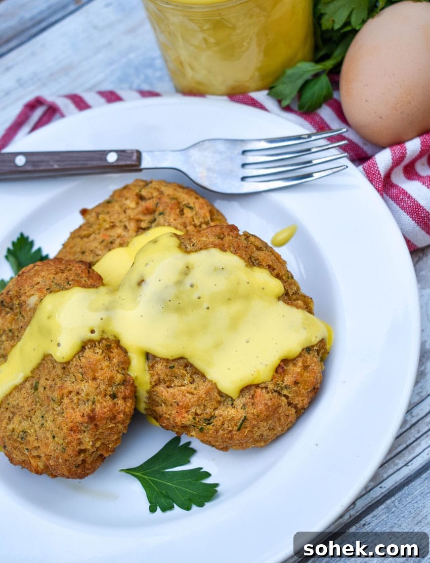 Quick Blender Hollandaise Sauce Recipe for Perfect Creamy Results 8 three crab cakes topped with blender hollandaise sauce on a small white plate