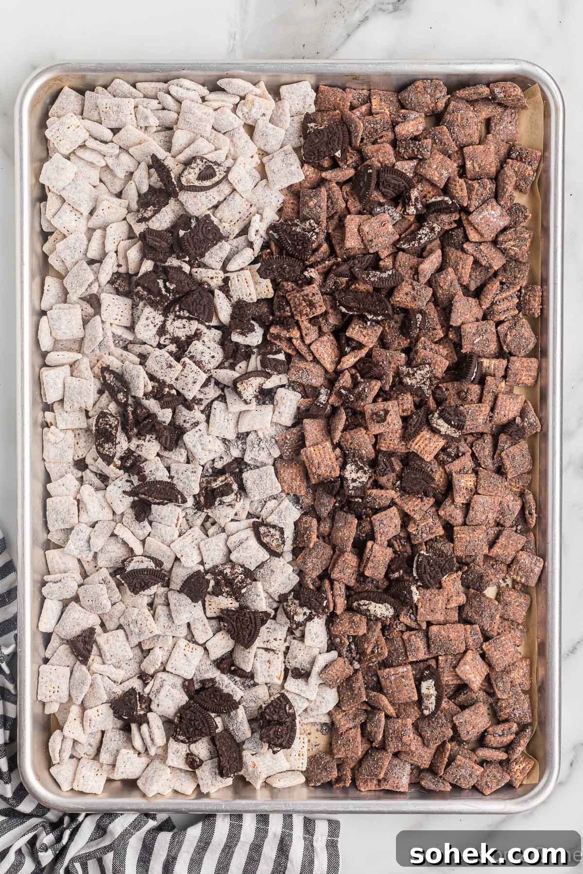 Oreo Puppy Chow Recipe: No-Bake Chocolate Cookie Snack 11 Cereal mixture spread on baking sheet.