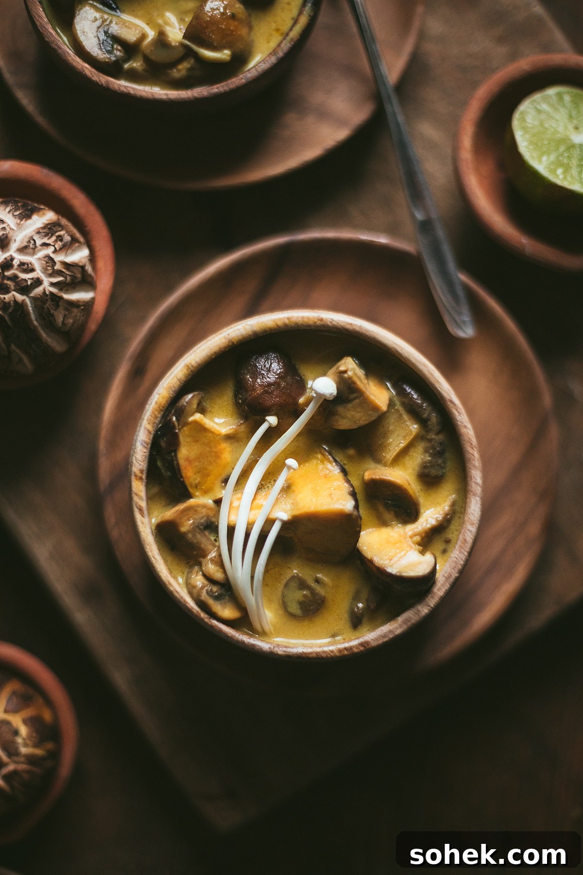 Creamy Kodava Mushroom Curry with Coconut Milk — Vegan Recipe 3 small dark wood bowl of mushroom curry with coconut milk garnished with enoki mushrooms