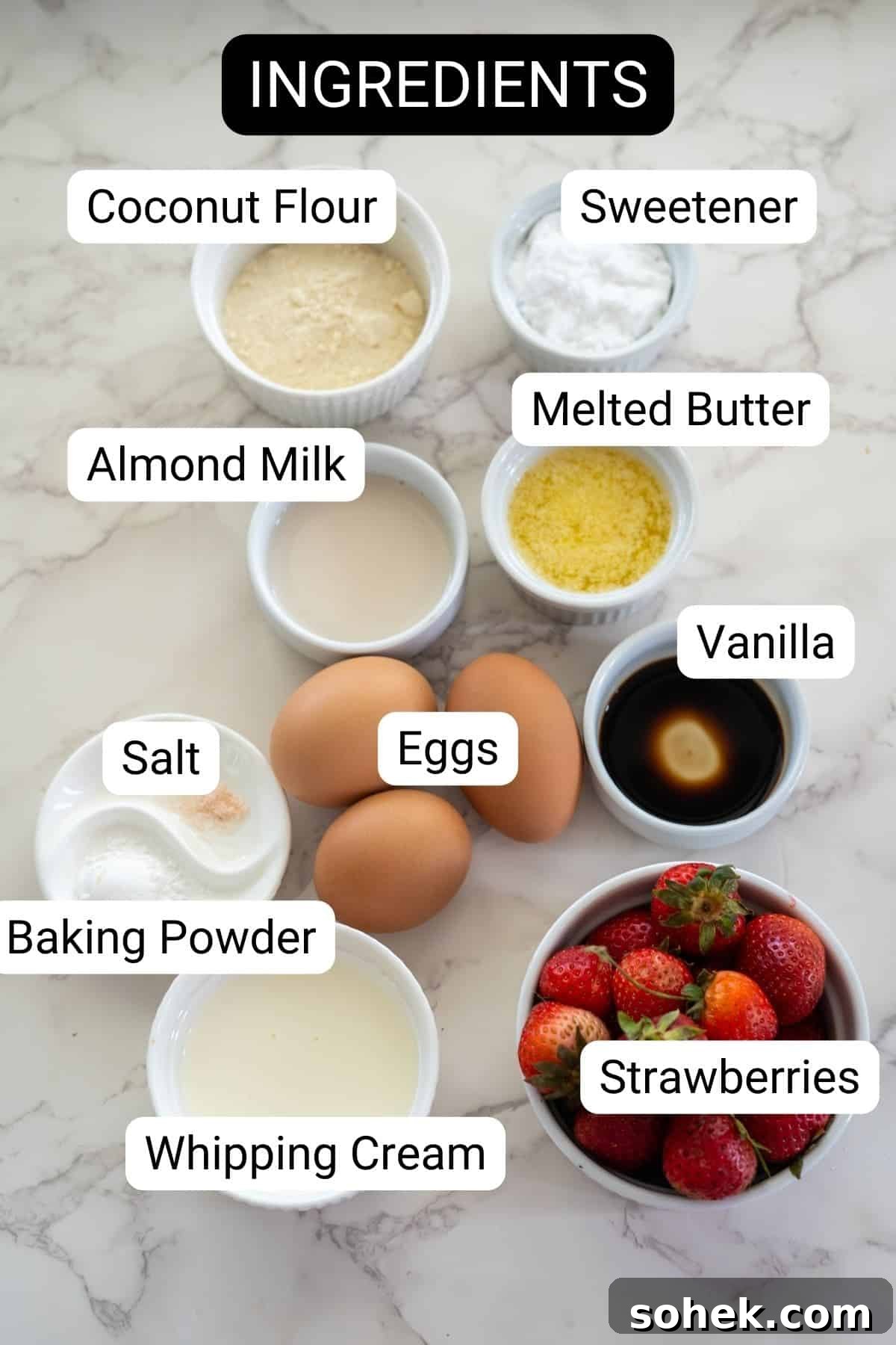 Strawberry Cream Cupcakes: Moist Vanilla Cupcakes with Fresh Strawberry Frosting 3 Ingredients for strawberry cream cupcakes laid out on a marble surface, including coconut flour, sweetener, almond milk, melted butter, vanilla, salt, baking powder, whipping cream, eggs, and strawberries.