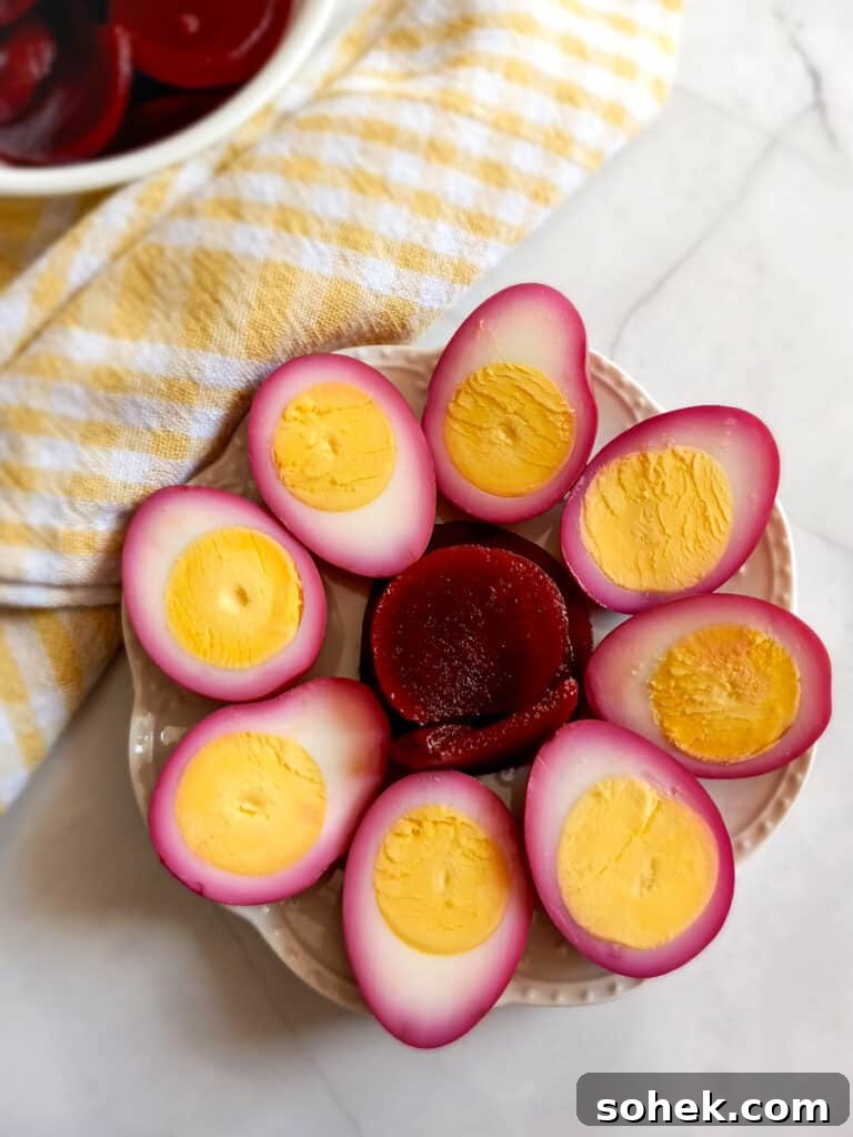 Authentic Amish Pickled Eggs and Beets Recipe for Tangy Flavor 10 halved pickled red beet eggs on a plate.