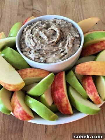 bowl of heath bar apple dip surrounded by slices of red and green apple