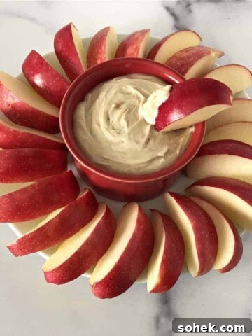 greek yogurt with peanut butter dip surrounded by apple slices