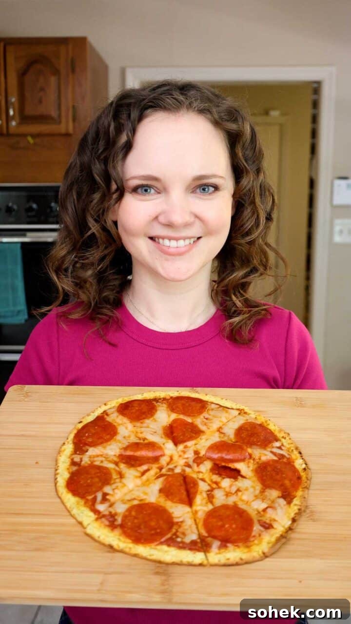 Cottage Cheese Pizza Crust Recipe: Thin, Chewy Low-Carb Base 11 Kelsey Smith holding a cutting board with a pepperoni pizza on top.