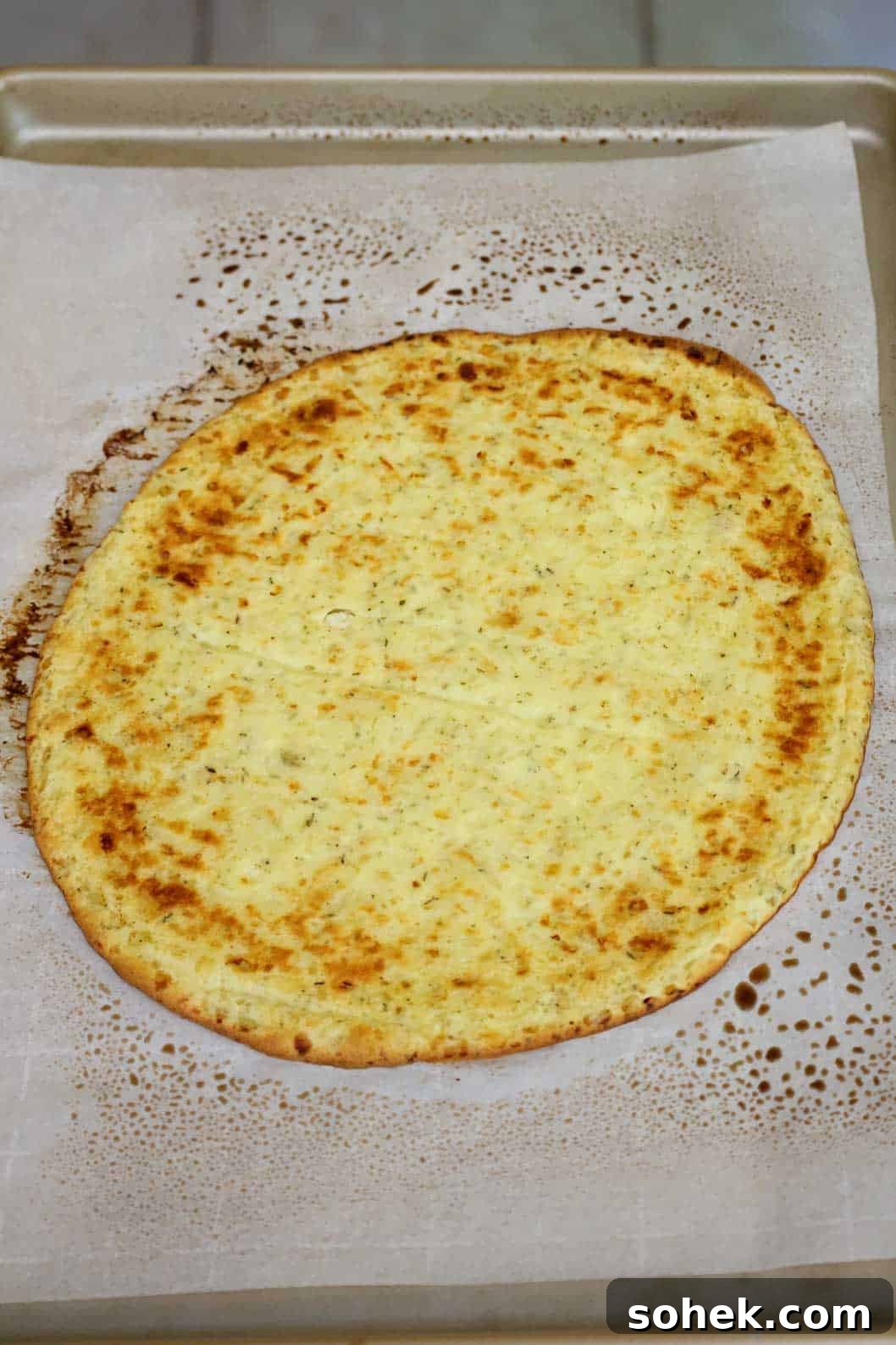 Cottage Cheese Pizza Crust Recipe: Thin, Chewy Low-Carb Base 8 A browned pizza crust on a baking sheet.