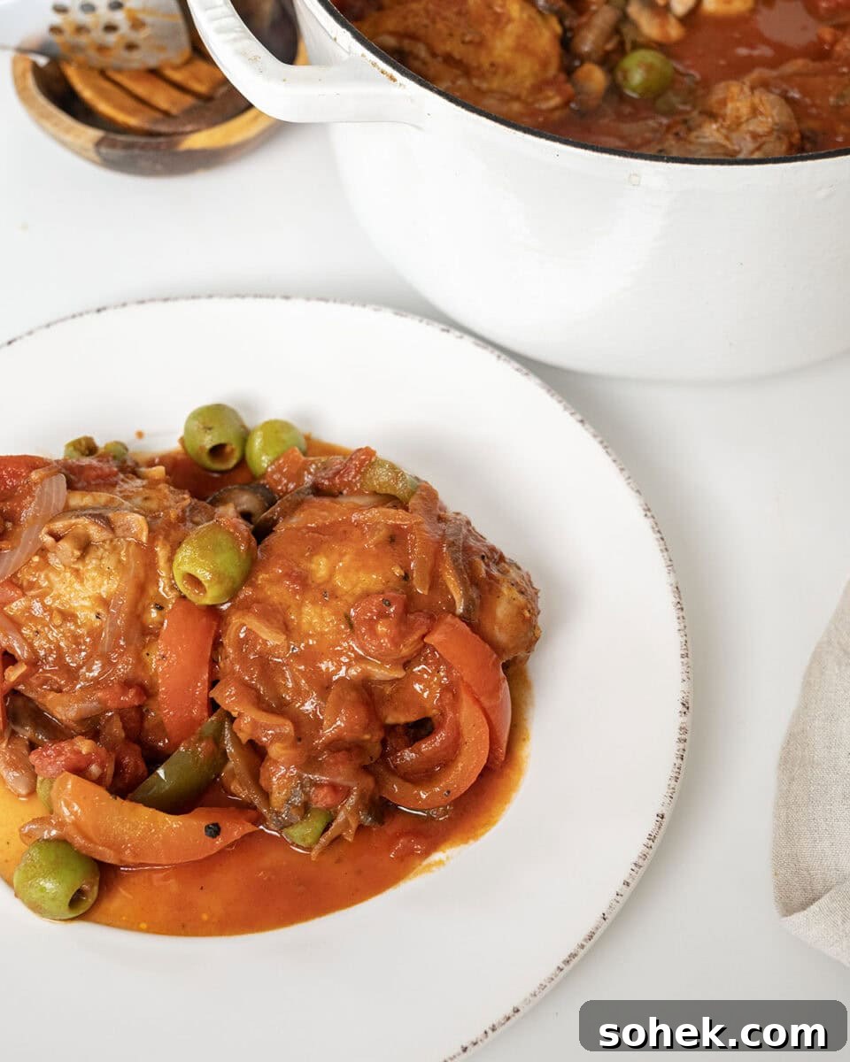 Finished chicken cacciatore on a plate and the remaining in a dutch oven.
