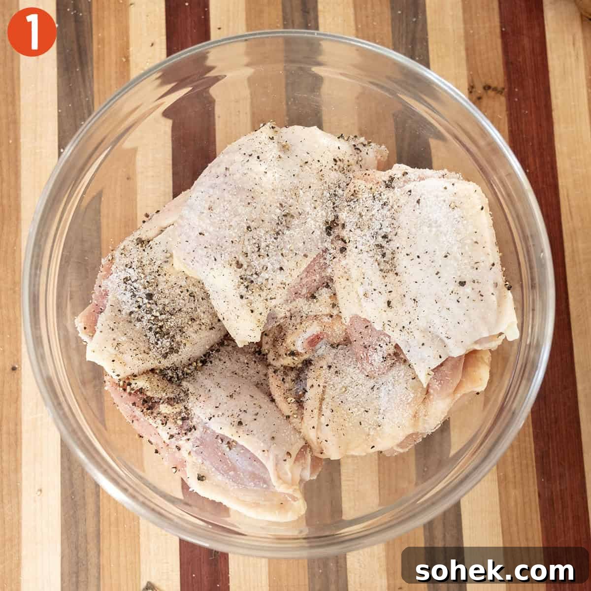Seasoned chicken thighs in a bowl.