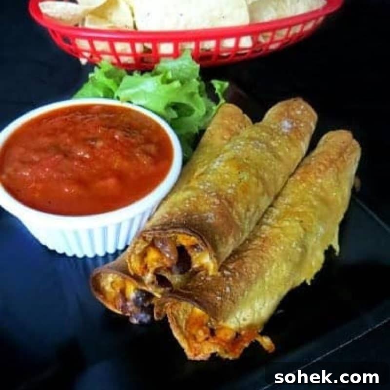 Corn and Black Bean Baked Taquitos on a black plate next to salsa