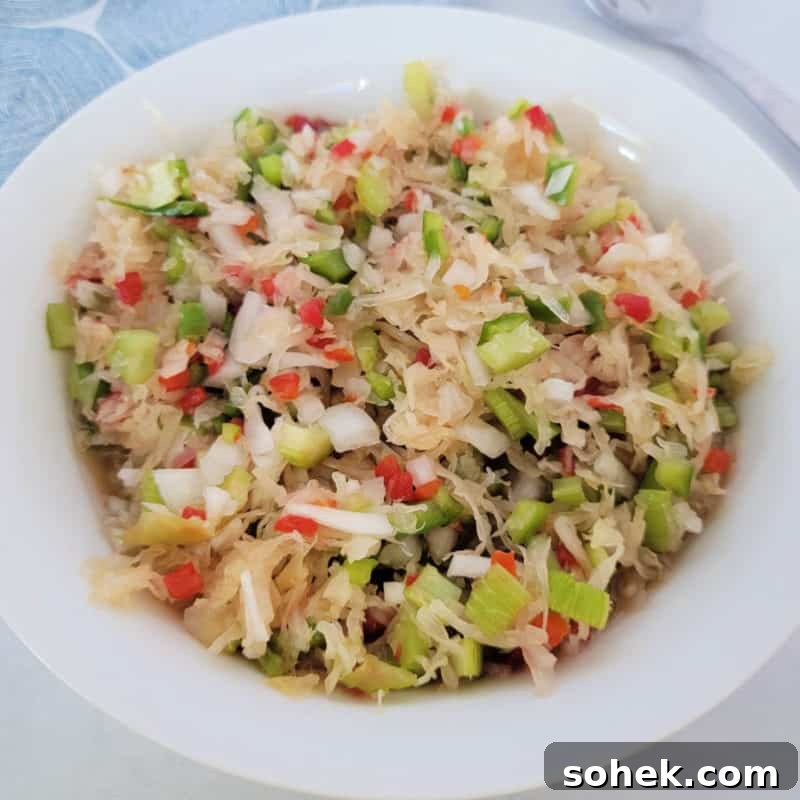 Sauerkraut Salad in a white bowl next to a fork