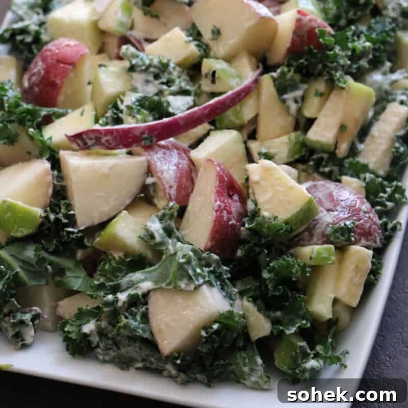 apple, kale, and potato salad on a white platter
