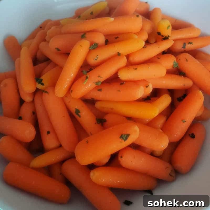 Carrots garnished with greens in a white bowl
