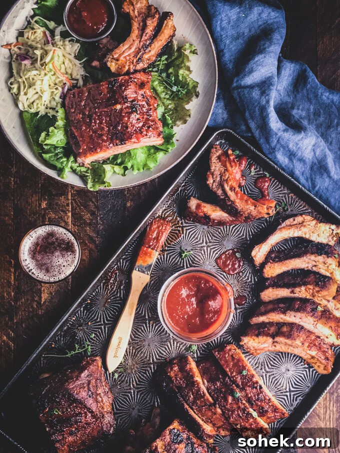 keto ribs on a sheet pan with BBQ sauce, and brush with bowl of salad ribs and keto coleslaw on the side.