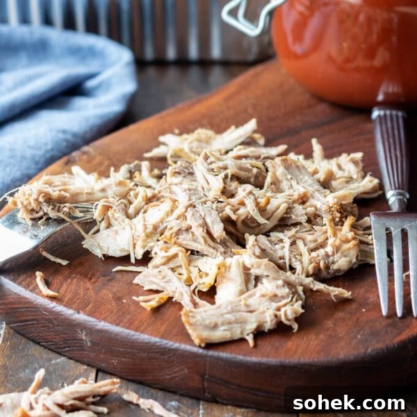Easy Pulled Pork Recipe is easily shredded with forks on a cutting board.