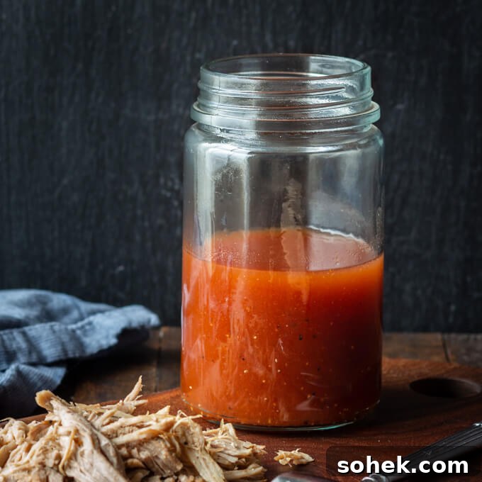 Carolina BBQ Sauce (apple cider vinegar sauce) in a jar with pulled pork.